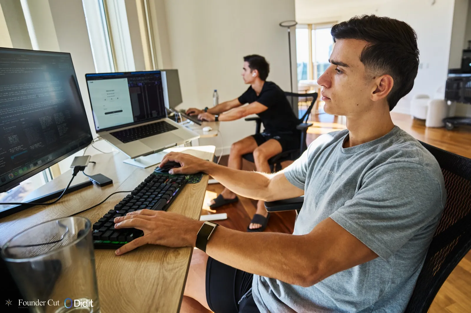 Alberto Rosas working at a desk with Alejandro in the background